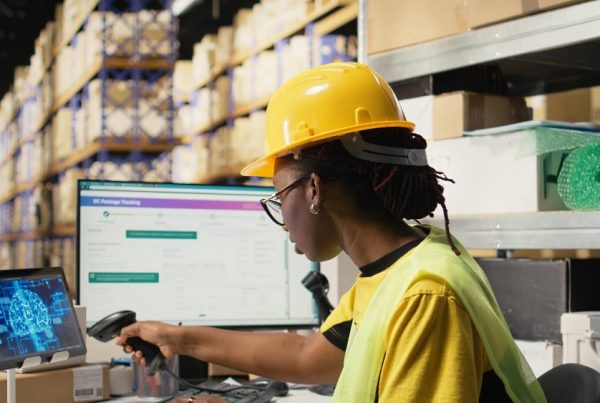 Mulher engenheira em armazém de logística usando tecnologia, computador e scanner para controle de estoque e otimização de processos.